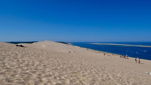 Scenic view of beach against clear blue sky