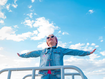 Little girl raised arms blue sky. happy child smiling flying in the air. lifestyle freedom happiness