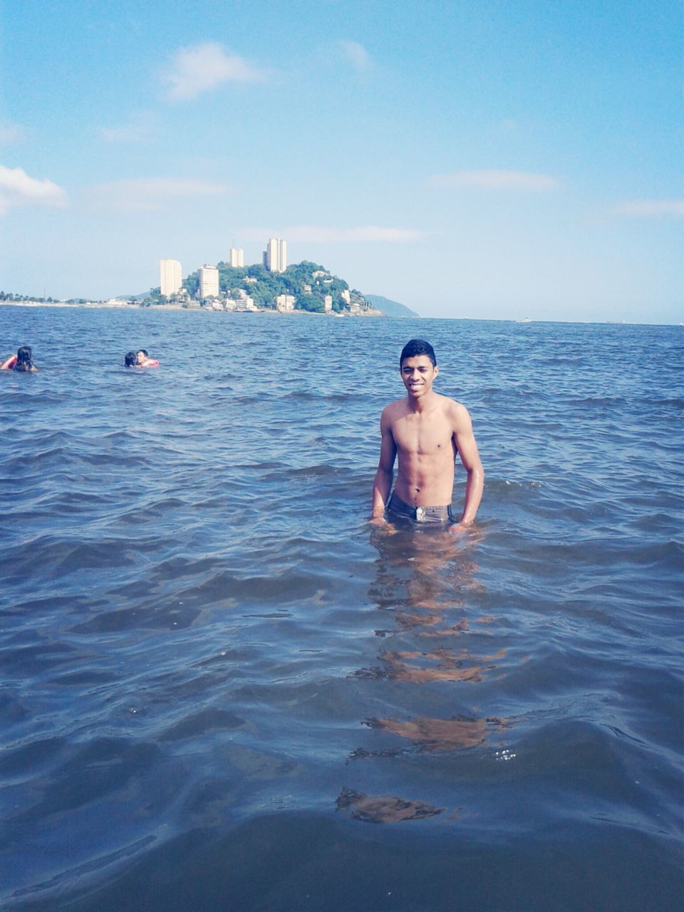 water, sea, lifestyles, leisure activity, person, waterfront, young adult, vacations, looking at camera, portrait, young men, enjoyment, sky, smiling, happiness, shirtless, blue