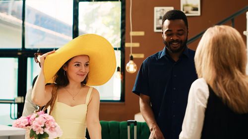 Portrait of smiling friends wearing hat while standing in cafe