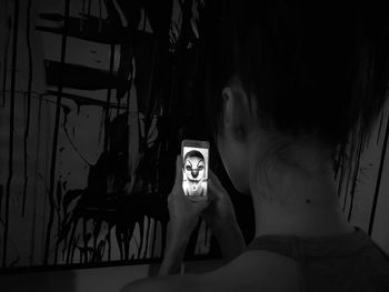 Portrait of woman standing against wall at home