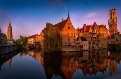 Reflection of buildings in water at sunset