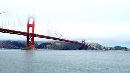 Low angle view of golden gate bridge over bay against sky