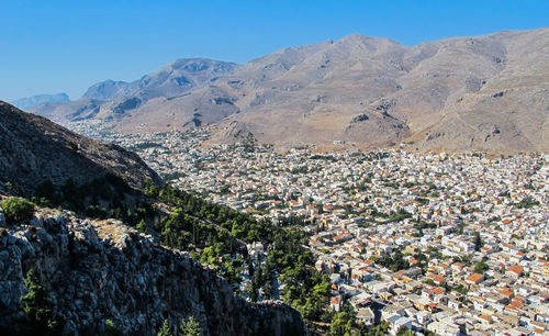 Aerial view of townscape and mountains against clear sky