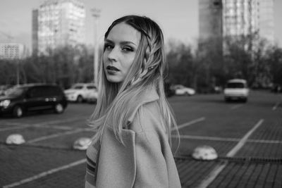 Portrait of beautiful woman standing in city black and white 