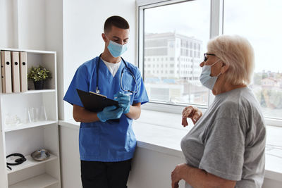 Doctor wearing mask examining patient at clinic