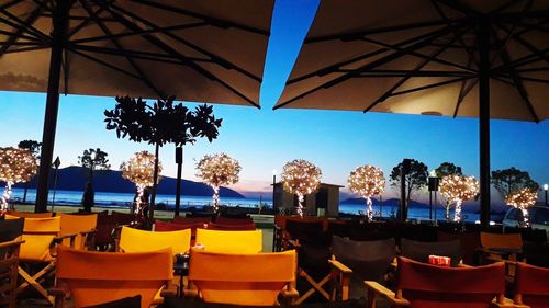 Chairs and tables at restaurant against sky