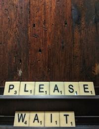 Close-up of text on wooden wall