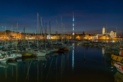 Sailboats moored in harbor