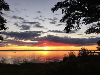 Scenic view of sea against cloudy sky during sunset