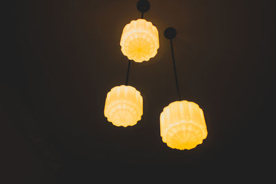 Low angle view of illuminated lighting equipment against sky at night