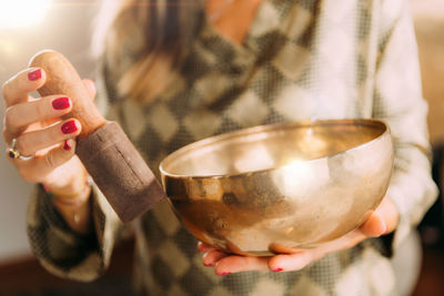 Woman playing tibetan singing bowl in sound healing therapy