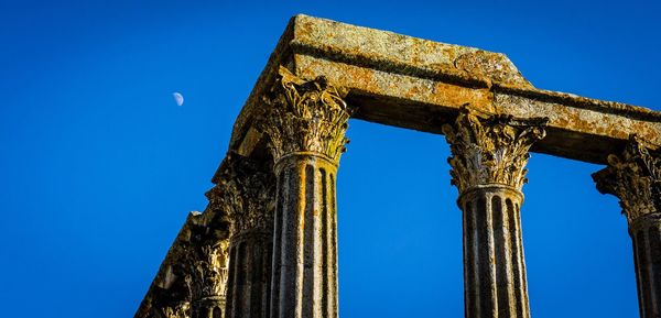 Low angle view of old temple against clear blue sky