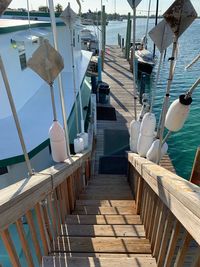 Boats moored at pier by sea