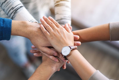 Cropped image of business people stacking hands