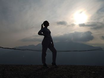 Full length of silhouette man standing on land against sky during sunset