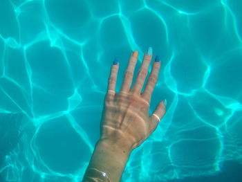 Midsection of woman swimming in pool