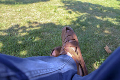 Low section of man relaxing on field