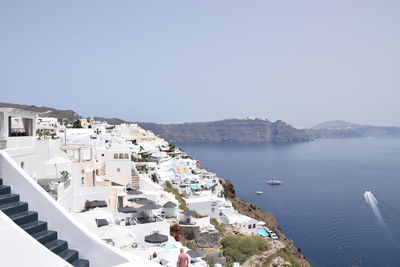 High angle view of townscape by sea against clear sky