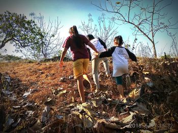 Rear view of people walking on land