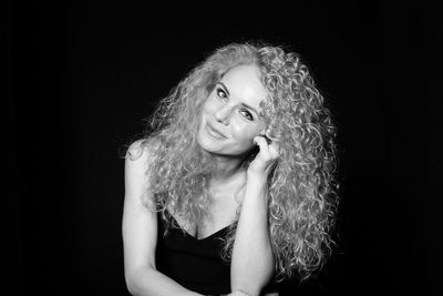 Portrait of a smiling young woman against black background