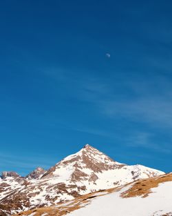 Scenic view of snowcapped mountains against blue sky