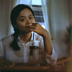 Portrait of mid adult man drinking glass on table