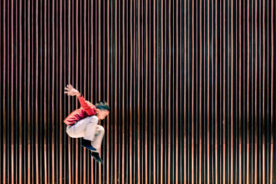 Boy jumping against wall