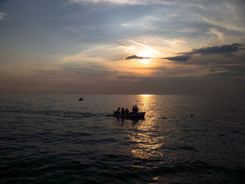 Silhouette boat in sea against sky during sunset