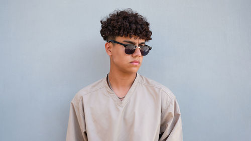 Portrait of young colombian man standing against white background