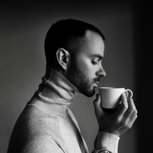 Side view of man drinking coffee at home