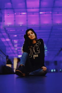 Portrait of beautiful young woman sitting on table