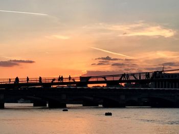 Bridge over sea against sky during sunset