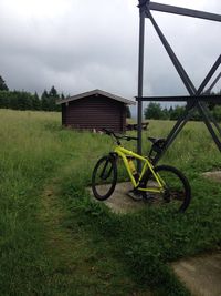 Grassy field against cloudy sky