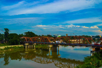 Bridge over river against cloudy sky