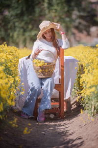 Full length of woman holding yellow flower