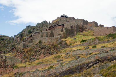 Low angle view of castle on mountain against sky