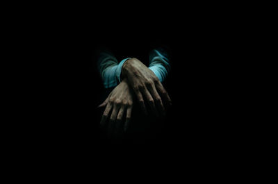 Digital composite image of hand against black background