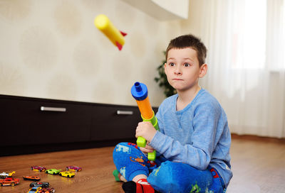 Boy playing with toy gun at home