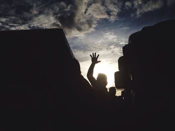 Close-up of silhouette hand against sky