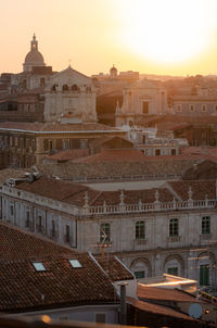 Buildings in city against sky during sunset