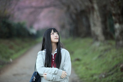 Portrait of beautiful young woman standing on land