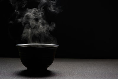 Close-up of coffee cup against black background