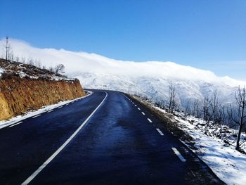 Empty road against sky during winter