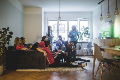 Male and female fans watching soccer match in living room