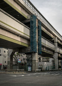 Low angle view of bridge against buildings in city