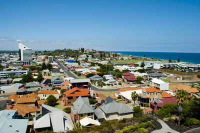 High angle view of townscape by sea against clear sky