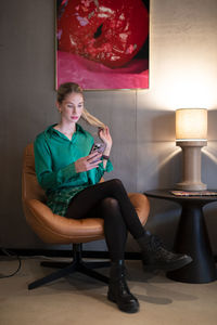 Young woman sitting on chair at home