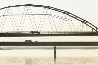 Cars driving through bridge at dusk