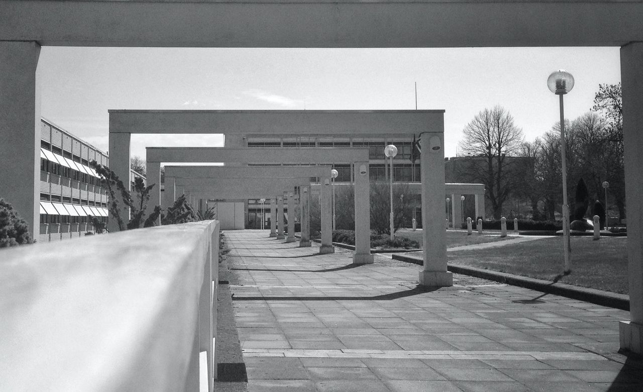 the way forward, architecture, built structure, building exterior, empty, diminishing perspective, walkway, railing, transportation, vanishing point, city, street, sky, tree, street light, footpath, sidewalk, day, long, sunlight